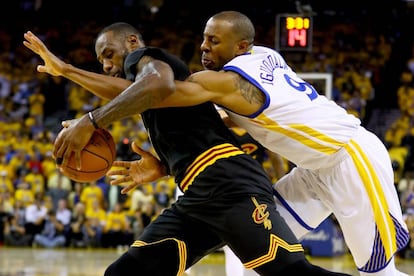 Iguodala trata de robarle el balón a LeBron James.