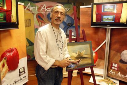 El artista José Ibarrola, ayer en Bilbao, ante uno de sus cuadros con la consola de Nintendo en las manos.