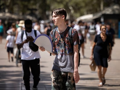 Un joven se abanica el pasado 18 de julio, en plena ola de calor, en la Rambla de Barcelona.