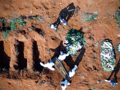 Trabalhadores do cemitério da Vila Formosa, em São Paulo, carregam um caixão nesta quarta-feira, 24 de março.