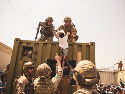 Militares ayudando a la evacuación de un niño este sábado en el aeropuerto internacional Hamid Karzai de Kabul.