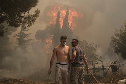 Voluntarios tratan de extinguir el fuego ardiendo cerca de Nea Penteli. 