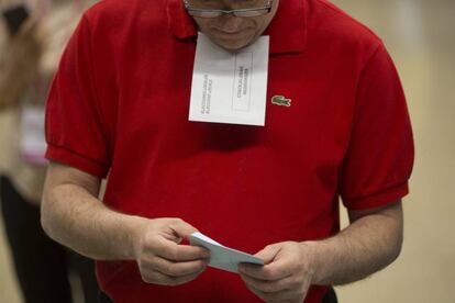 Un ciudadano prepara su papeleta electoral en el colegio público La Sedeta, en Barcelona.