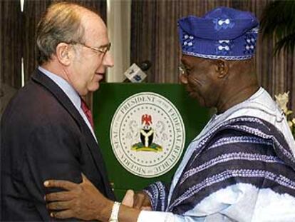 Rodrigo Rato saluda al presidente nigeriano, Olusegun Obasanjo.
