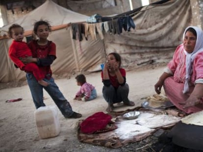 Una mujer cocina pan cerca de la ciudad de Alepo.