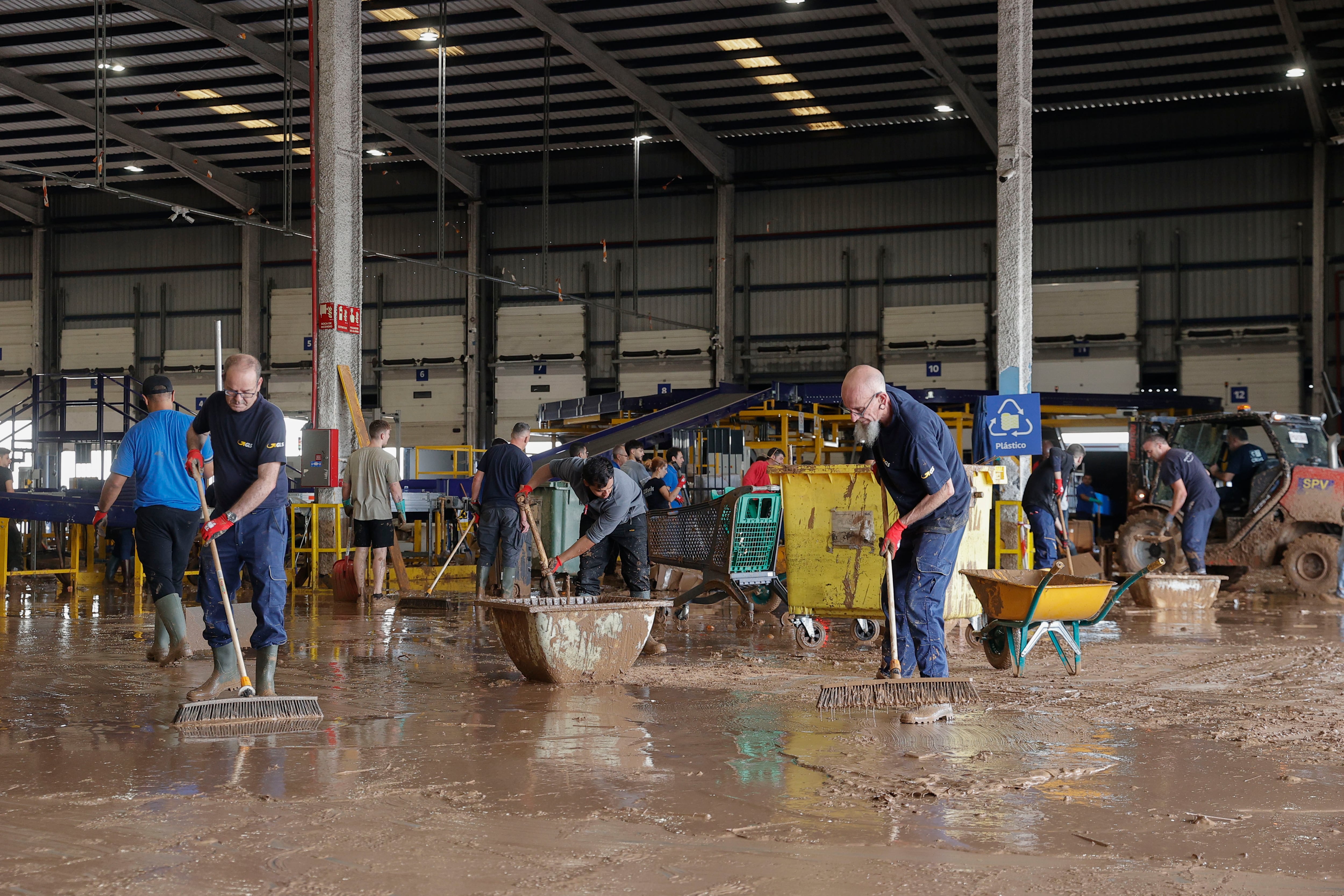 Trabajadores de una empresa de logística limpian el interior de una nave en el polígono industrial de Riba-roja de Túria, en una imagen del 1 de noviembre.