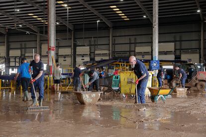 Trabajadores de una empresa de logística limpian el interior de una nave en el polígono industrial de Riba-roja de Túria, el día 1.