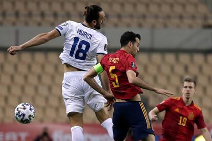 El centrocampista de la selección española Sergio Busquets (centro) pelea un balón con el delantero de Kosovo Vedat Muriqi durante el partido de clasificación para el Mundial Qatar 2022, este miércoles en el estadio de la Cartuja de Sevilla.