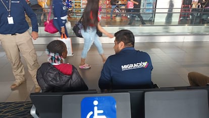 Un agente migratorio habla con una niña abandonada en el aeropuerto de Bogotá, el pasado 17 de diciembre.