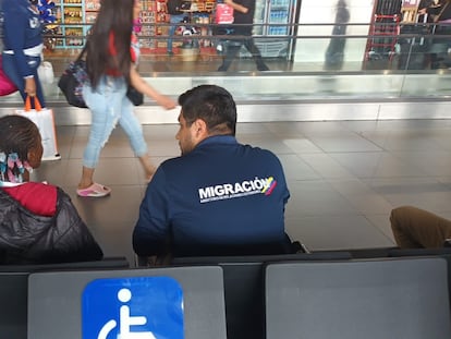 Un agente migratorio habla con una niña abandonada en el aeropuerto de Bogotá, el pasado 17 de diciembre.