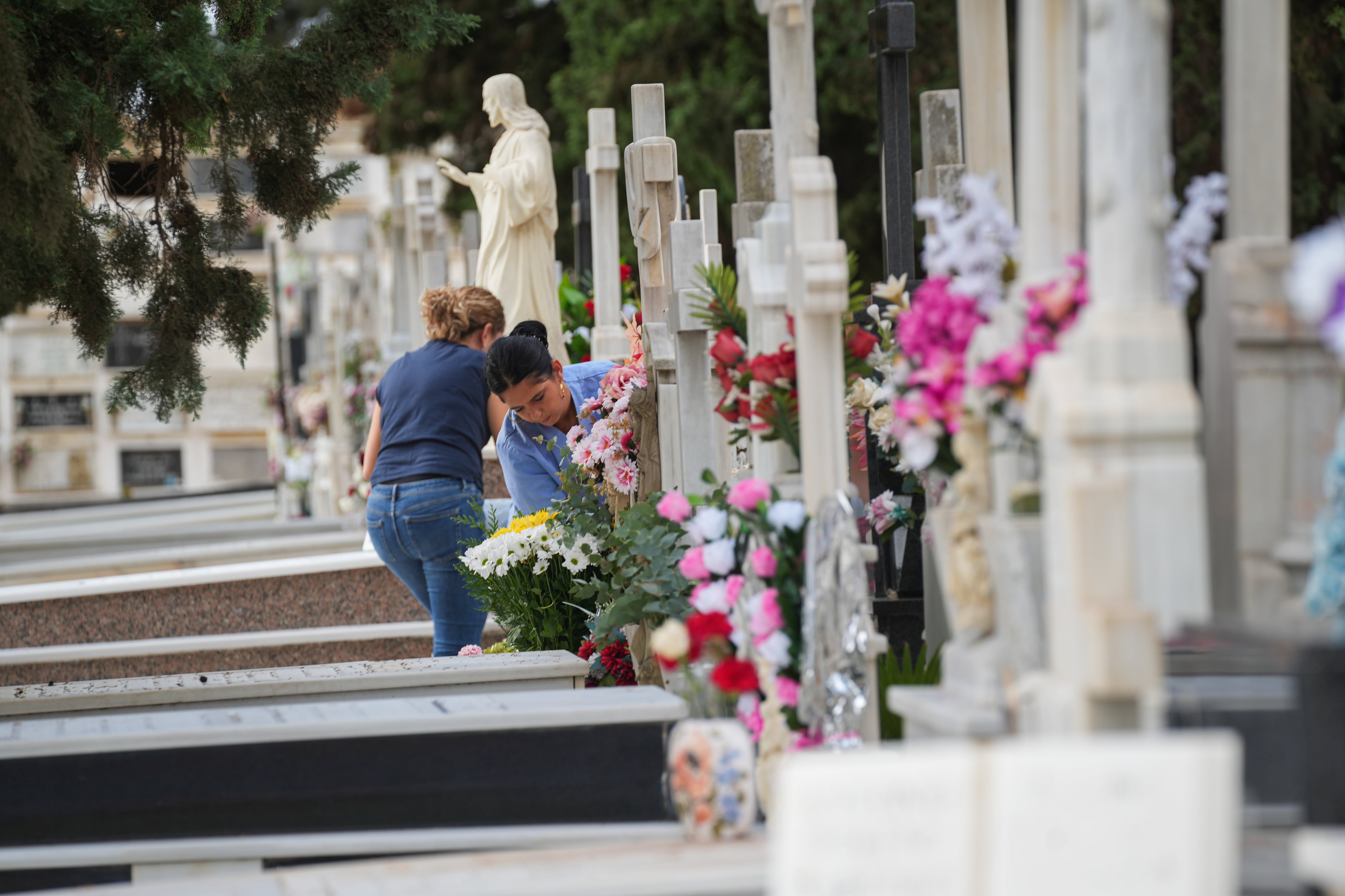 Personas llevan flores a un ser querido, en el Cementerio de San Fernando, el 31 de octubre de 2025, en Sevilla (Andalucía, España).