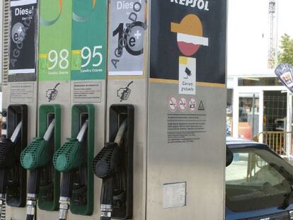 Un joven pone gasolina a su coche en un surtidor Repsol.