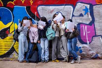 Un grupo de adolescentes repasan apuntes en una calle de Valencia.