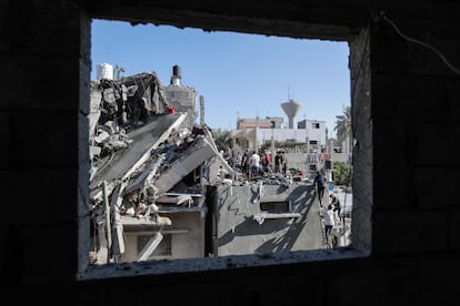 Varias personas buscan entre los edificios destrozados durante los bombardeos israelíes de ayer, este jueves en Jan Yunis.