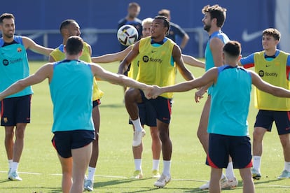 El defensa francés del Barcelona, Jules Koundé, en el centro junto a Gerard Piqué, en el entrenamiento del equipo este sábado.