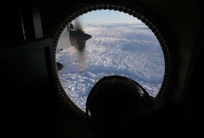 Una investigadora observa un glaciar de Groenlandia desde la ventana de un avión de investigación.