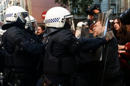 Agentes de la Guardia Urbana de Barcelona impiden el avance de las decenas de personas que protestan ante el dispositivo puesto en marcha a primera hora de esta ma?ana para recuperar el edificio conocido como la Antiga Escola Massana.
