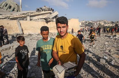Jóvenes palestinos recolectan coranes cerca de una mezquita destruida en Jan Yunis, este miércoles, en la franja de Gaza. 