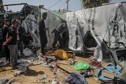 Ciudadanos palestinos inspeccionan un refugio destrozado por ataques israelíes cerca del hospital de Al Aqsa en el sur de Gaza este domingo.