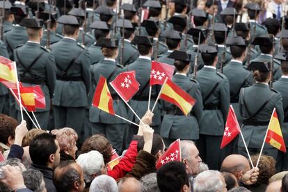 Un grupo de asistentes al desfile conmemorativo de la festividad del Dos de Mayo en la Puerta del Sol ondea sus banderitas.