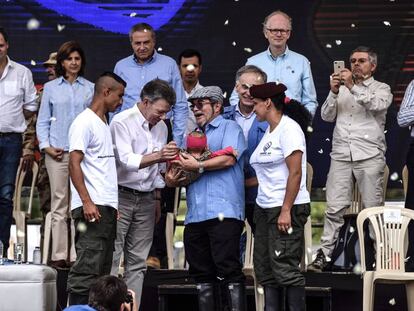 Guerrilheiros entregam bebê a Rodrigo Londoño, líder das FARC, e ao presidente Juan Manuel Santos em ato de entrega das armas