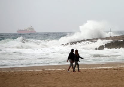 Así, el riesgo por nevadas afectará a León, Lugo, Orense, Zamora y Asturias, mientras las lluvias colocarán en situación de riesgo a La Coruña. Por otro lado, el fuerte oleaje afectará con aviso amarillo a Pontevedra, La Coruña, Lugo, Asturias, Cantabria, Vizcaya, Guipúzcoa, Mallorca y Menorca. En la imagen, una pareja pasea por la playa de l'Arrabassada (Tarragona) en medio del temporal que está afectando a Cataluña.