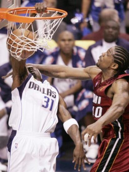 Jason Terry (i), de los Mavericks,  hace un <i>mate</i> ante Udonis Haslem, de los Heat, en el primer partido de la final, en Dallas.