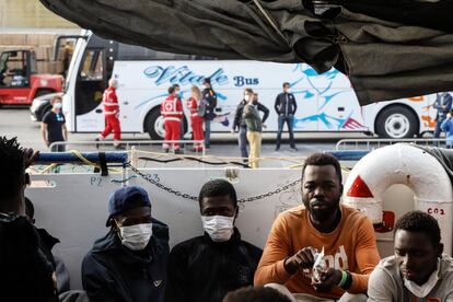 El 22 de octubre, las autoridades italianas dieron permiso al 'Sea Watch 3' para desembarcar a los migrantes en el puerto de Pozzallo, al sureste de Sicilia. A todos ellos se les realizó la prueba de covid-19 antes de pisar tierra, y después se les envió a distintos lugares para hacer cuarentena. En la foto, migrantes sentados en la cubierta mientras el barco inicia las maniobras de atraque, el 23 de octubre de 2021.