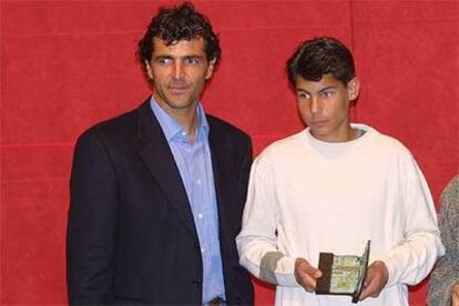 Rafa Nadal, en su época infantil, recoge un trofeo junto a su tío Miquel Àngel, ex futbolista.