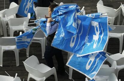 Un ni&ntilde;o recoge los banderines del PP tras el mitin de Rajoy en Sevilla.
 