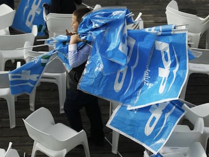 Un ni&ntilde;o recoge los banderines del PP tras el mitin de Rajoy en Sevilla.
 