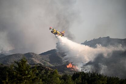 Un hidroavión lanza agua sobre las llamas en la localidad de Vati, en la isla de Rodas, este martes. 