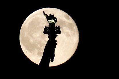 A tocha da Estátua da Liberdade, com a ‘lua azul’ de fundo, vista da cidade de Nova Jersey (Estados Unidos).