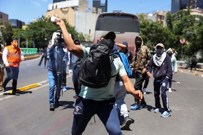 manifestante lanza un objeto a la policía durante una marcha por el caso Ayotzinapa