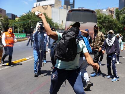 manifestante lanza un objeto a la policía durante una marcha por el caso Ayotzinapa