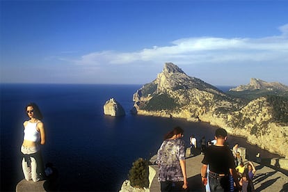 Visitantes en el impresionante mirador de Es Colomer, a 232 metros sobre el nivel del mar (el islote de Colomer al fondo), en el cabo de Formentor, al norte de Mallorca.