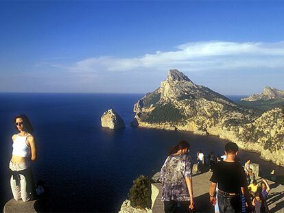 Visitantes en el impresionante mirador de Es Colomer, a 232 metros sobre el nivel del mar (el islote de Colomer al fondo), en el cabo de Formentor, al norte de Mallorca.