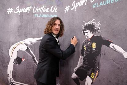 Carles Puyol firma un mural con su fotografía a su entrada a los premios Laureus, celebrados en Berlín. 