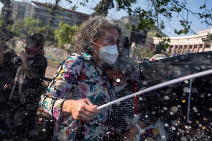 Dos mujeres reciben el chorro de una tanqueta antidisturbios, el 18 de octubre de 2023 en Santiago (Chile).