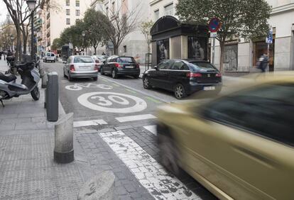 Dos vehículos pasan por una calle del centro de Madrid limitada a 30 kilómetros por hora.
