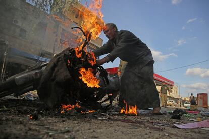 Un sirio junto a una motocicleta en llamas en el lugar de la explosión de un coche bomba en la ciudad de Tal Abyad, en la zona kurda del norte de Siria, el sábado 2 de noviembre.