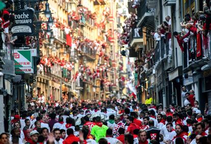 Vista general de los participantes del cuarto encierro de los Sanfermines, este miércoles en Pamplona. Cada día del festival, a las ocho de la mañana, se liberan seis toros para correr a través de las calles estrechas y empedradas del casco antiguo 850 metros. Por delante de ellos, están los corredores, que intentan mantenerse cerca de los toros sin caerse ni ser corneados.