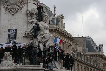 Diversos manifestants se situen a la base de l'estàtua de Marianne a la Plaça de la República, París.