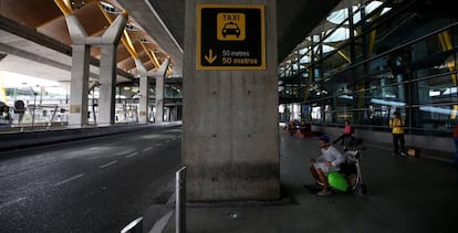 Un hombre espera sentado frente a la fila de taxis de la T4 de Madrid, vac&iacute;a durante el pasado martes por la huelga de estos profesionales.