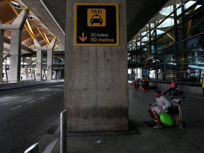 Un hombre espera sentado frente a la fila de taxis de la T4 de Madrid, vac&iacute;a durante el pasado martes por la huelga de estos profesionales.