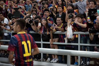 Decenas de aficionados fotograf&iacute;an a Neymar desde la grada del Rajamangala.