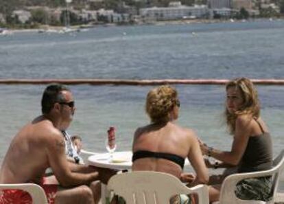 Unos turistas conversan en una terraza en la playa ibicenca de Talamanca. EFE/Archivo