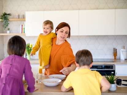 Una madre prepara el desayuno para sus tres hijos.