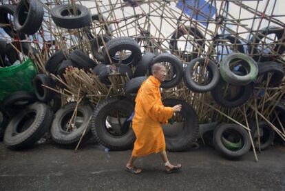 Un monje budista camina junto a las barricadas levantadas por los <i>camisas rojas</i> en el centro de Bangkok.
