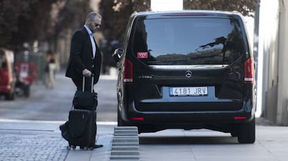 Un vehículo VTC, recoge a un viajero en Madrid.